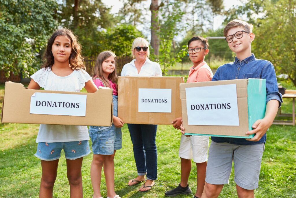 Fundraise with us - group of kids and a woman holding donations